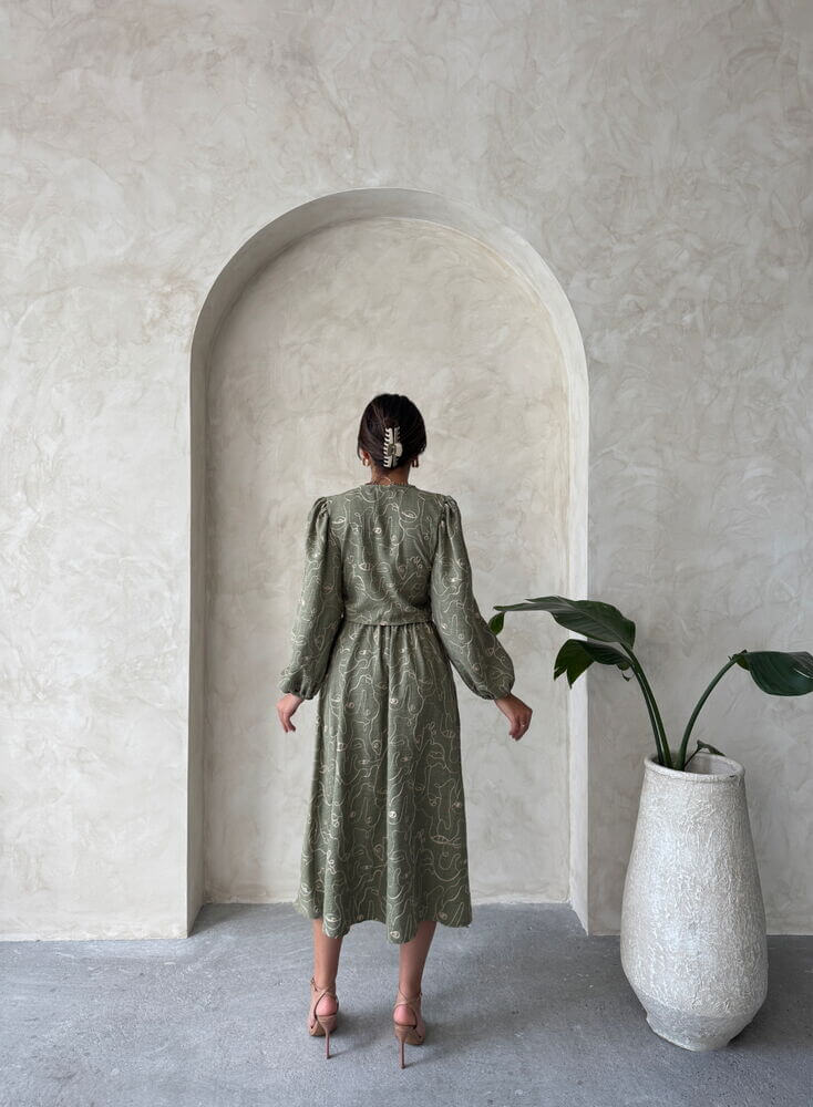 Back view of a woman in a Boho print linen two-piece set, standing in a stylish archway with a plant.