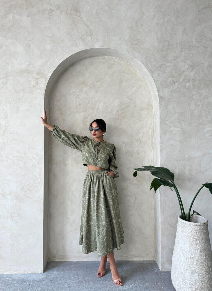 Model in a Boho print linen two-piece set, featuring a chic blouse and skirt, styled against a minimalist backdrop.