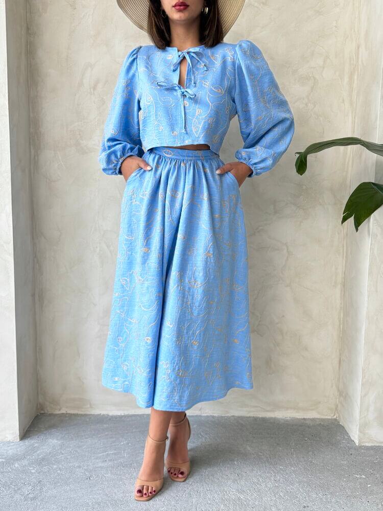Model wearing a Boho print two-piece linen set in light blue, featuring a blouse and matching skirt.