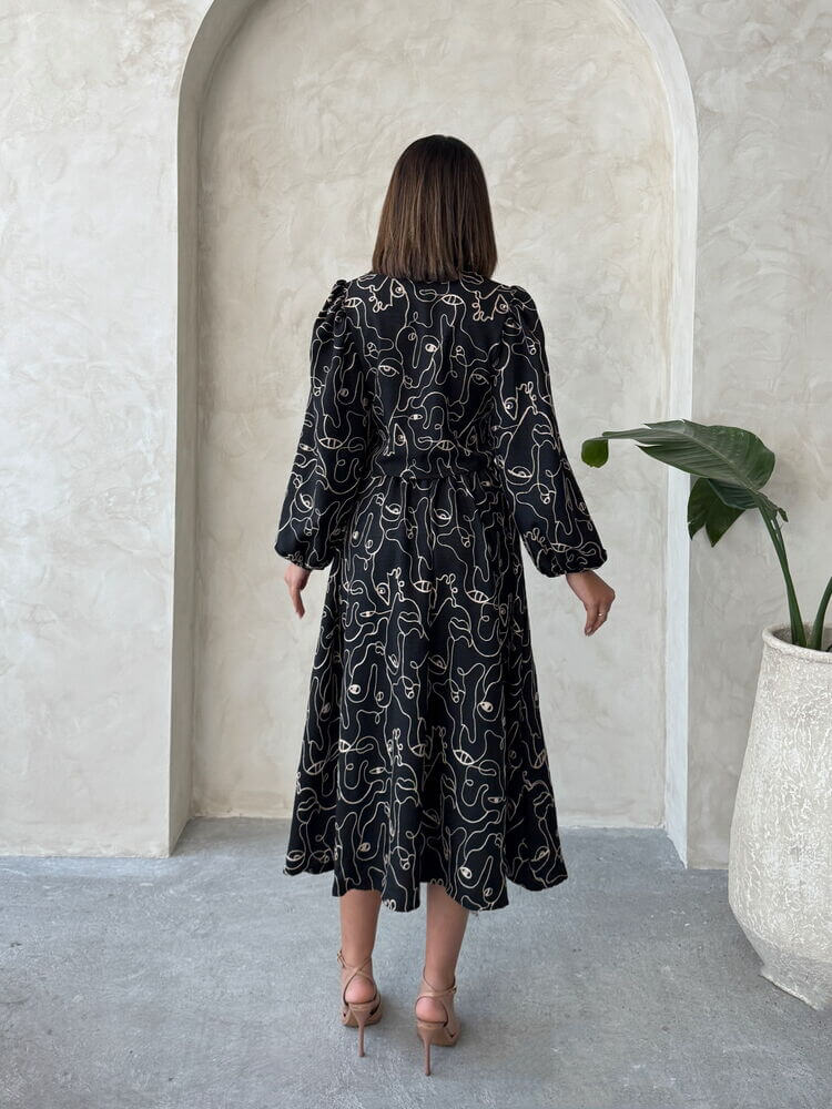Back view of a woman in a Boho printed linen dress standing in a stylish indoor setting.