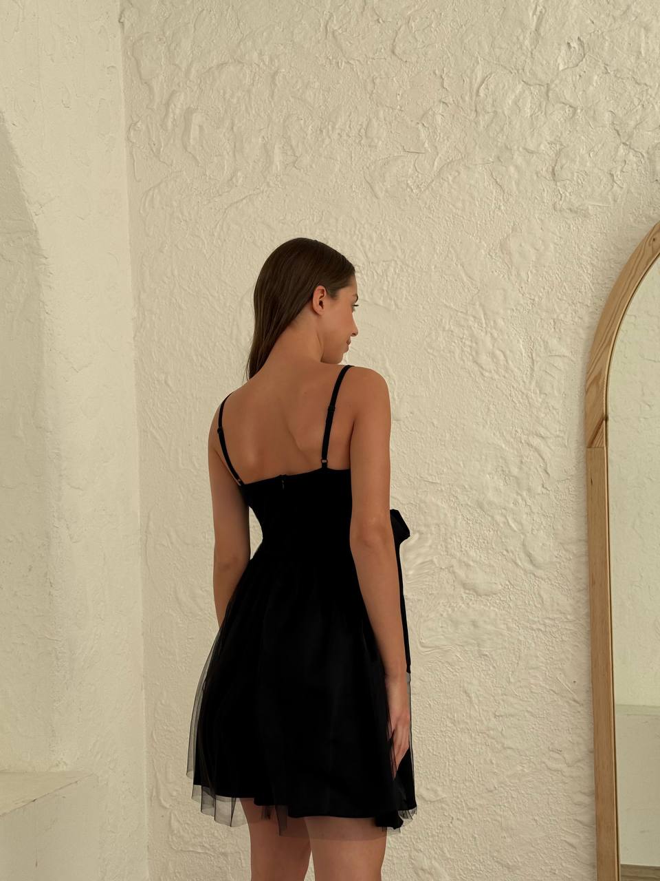 Back view of a black fit-and-flare mini dress, perfect for evening events.