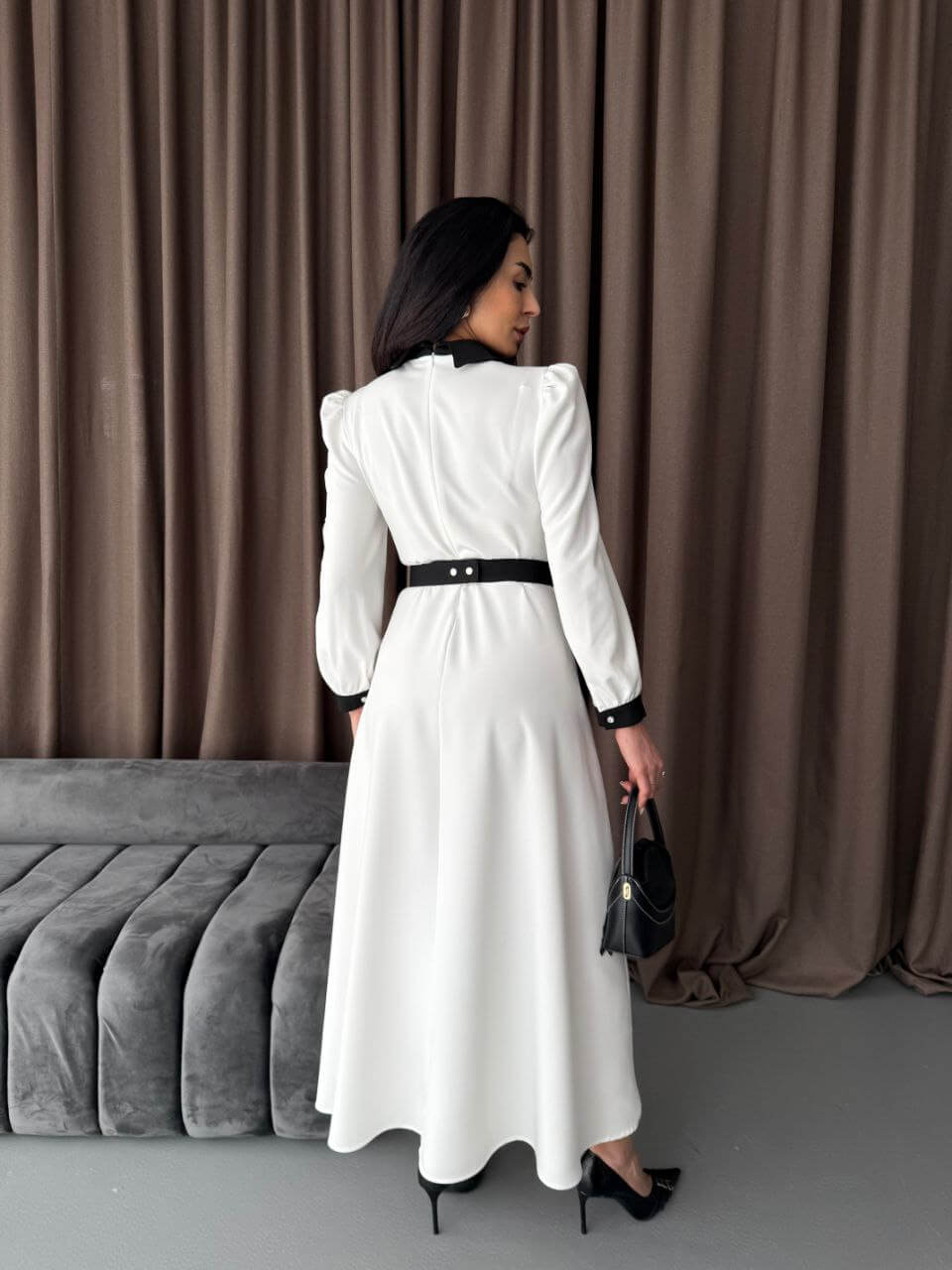 The back of the white and black maxi dress, showing its tailored fit and elegant length.

