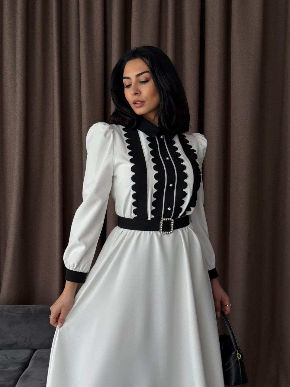 A detailed view of the white and black maxi dress, emphasizing the fabric texture and button-up style.
