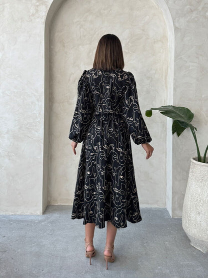 Back view of a woman in a Boho printed linen dress standing in a stylish indoor setting.