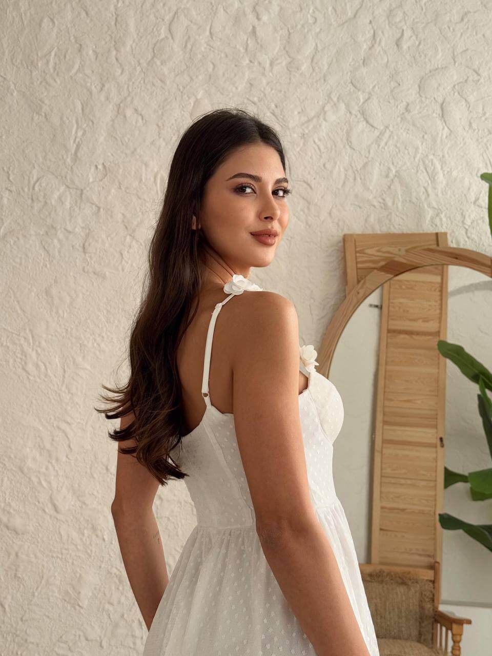 Back view of a white fit-and-flare mini dress, ideal for summer gatherings.