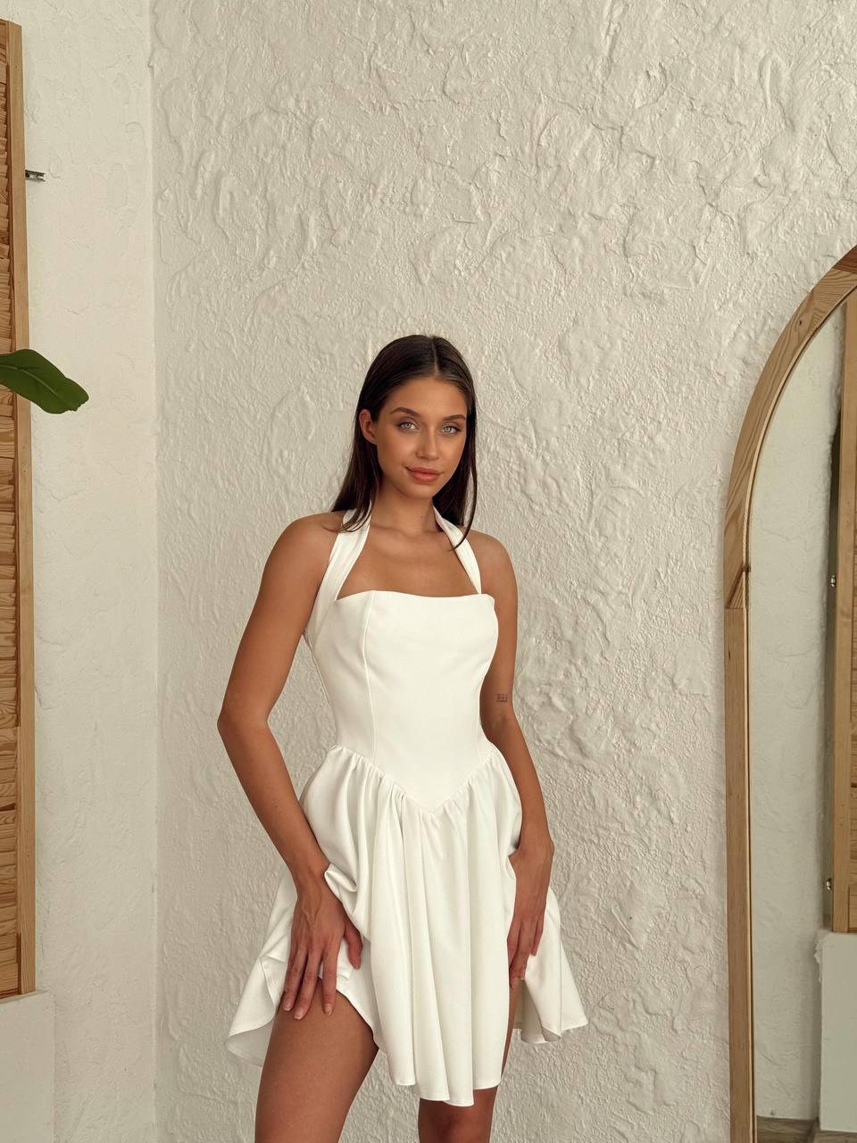 Short white-colored dress with a halter neckline, open back, and flared skirt.