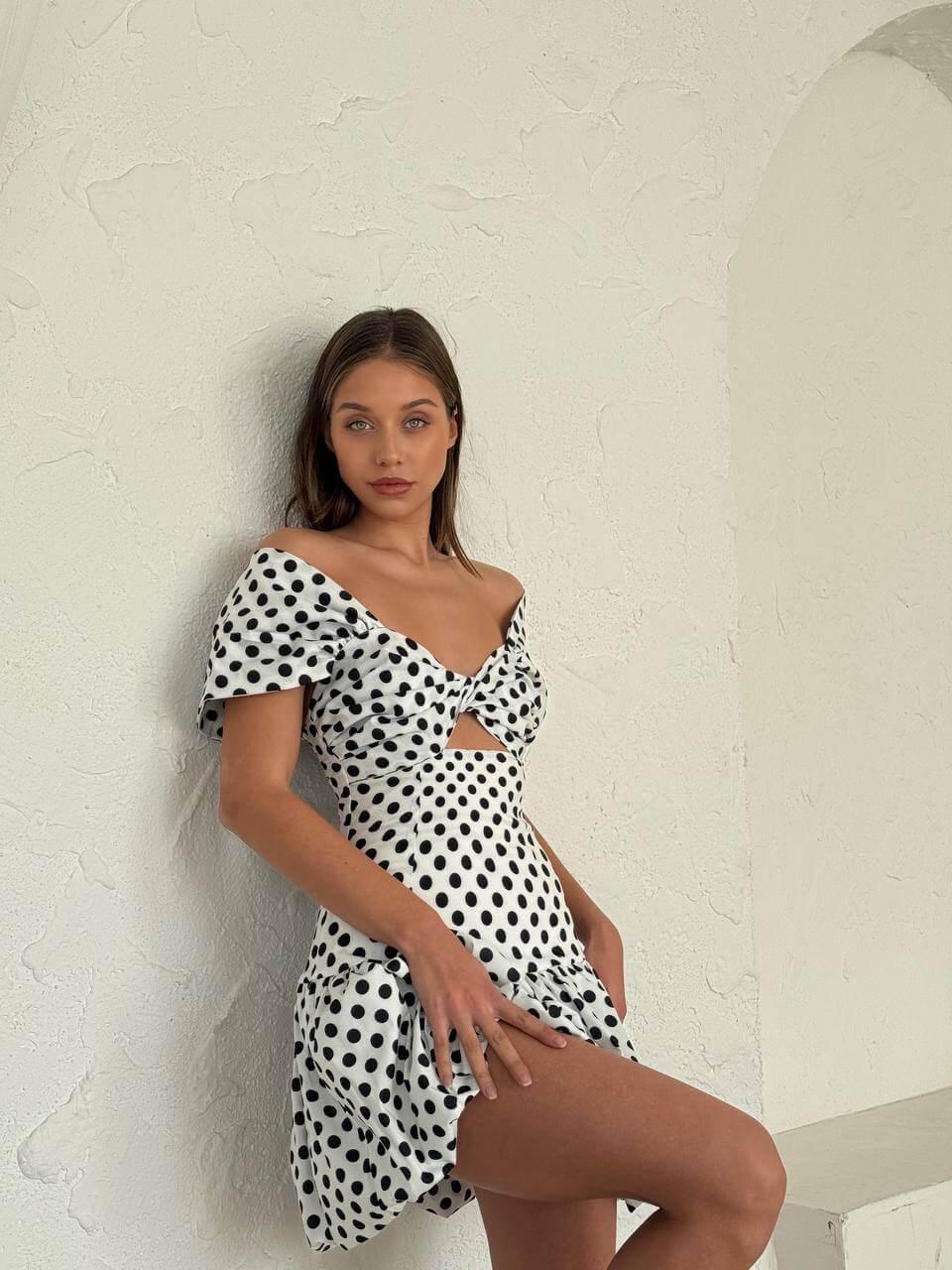 Women's short black and white polka dot dress with off-the-shoulder sleeves and a semi-flared skirt