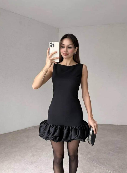 Black sleeveless short dress with pin-pleated skirt.