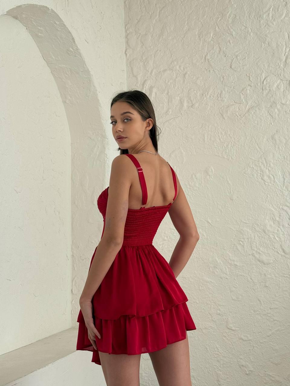 Red sleeveless short dress with pin-pleated skirt above the knee.