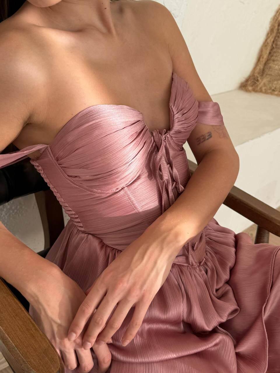 Pink sleeveless short dress with pin-pleated skirt above the knee.
