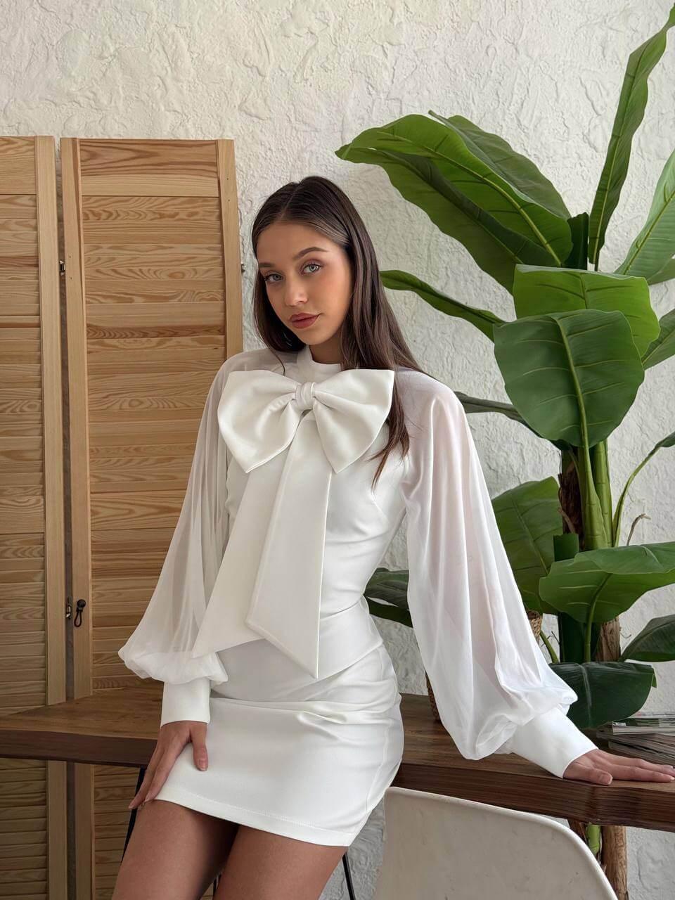 White long-sleeve short dress with a bow-tie collar.