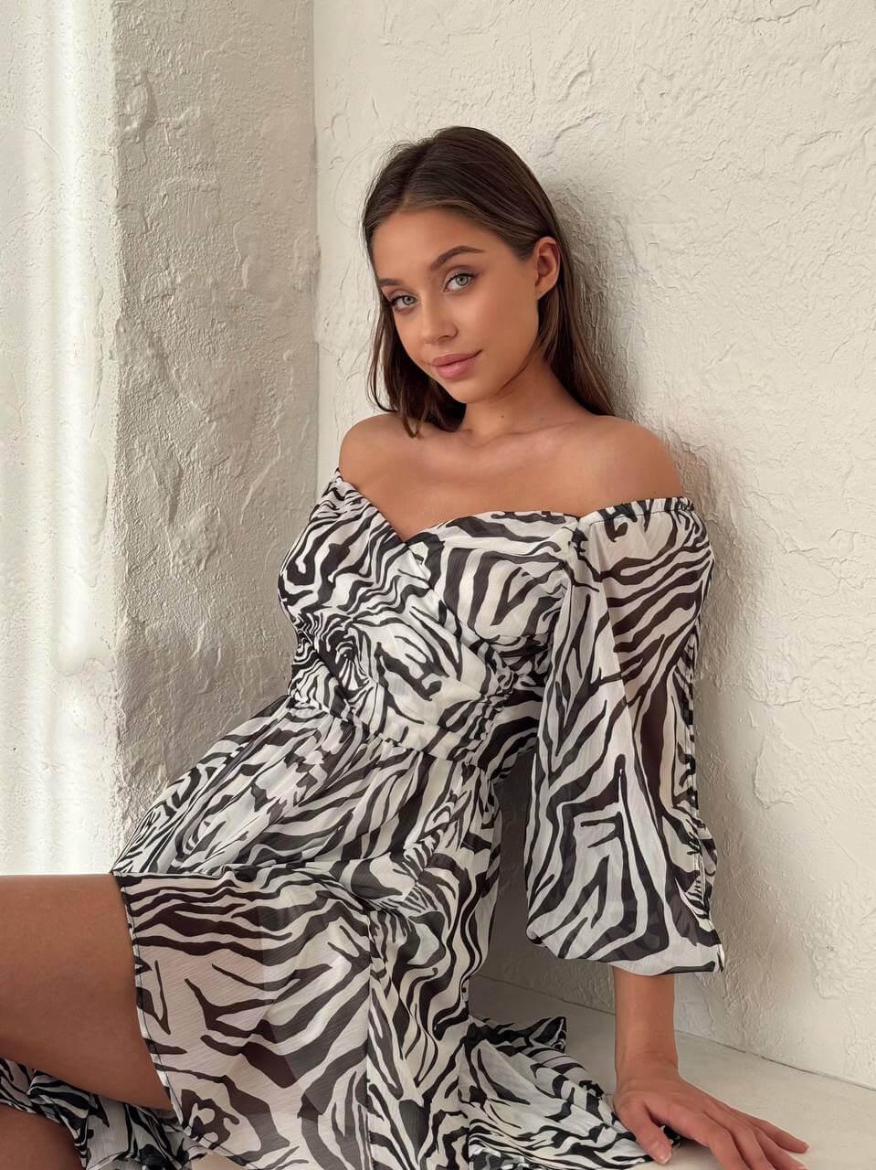 Women's short zebra-print dress with an open back, deep front neckline, long slit sleeves.