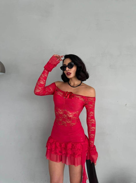  It features an off-the-shoulder design with long sleeves and lace tulle detail. The model is wearing the red version of the dress